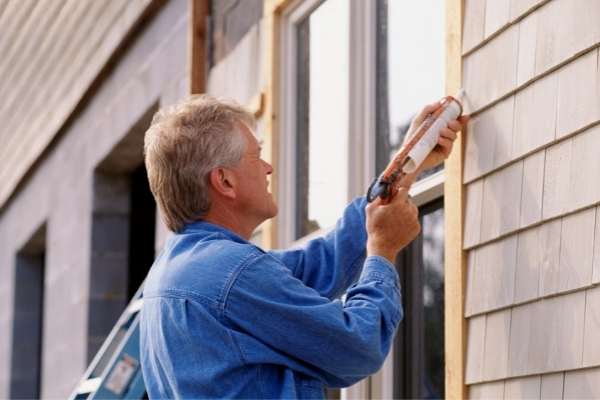 Home inspector caulking a window in south carolina