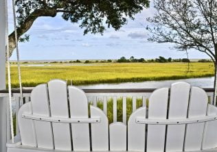 Wine Time - Backs of two white wood chairs in front of the marsh